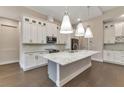 Modern kitchen featuring white cabinets, large island, and hardwood floors at 5451 Prime Ter, North Port, FL 34286