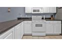 Condo kitchen with white cabinets, granite counters, and stainless appliances at 150 Harborside Ave # 216, Punta Gorda, FL 33950