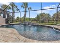 Inviting kidney-shaped pool with a waterfall feature and screened enclosure at 13064 Creekside Ln, Port Charlotte, FL 33953