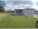 Mobile home with carport, spacious yard, and mature trees at 6900 Awawa Ct, North Port, FL 34287