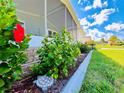 Landscaped yard with lush greenery and vibrant hibiscus flowers at 743 Tangerine Woods Blvd, Englewood, FL 34223