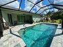 Screened-in pool with brick patio, landscaping, and beautiful clear blue water at 4767 Maurbach Ter, North Port, FL 34286