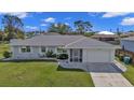 Charming home with landscaped yard, white rock accents, and well-maintained lawn at 17341 Sabrina Cir, Port Charlotte, FL 33948