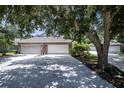 Three-car garage with American flag and lush landscaping at 1274 White Oak Trl, Port Charlotte, FL 33948