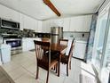 Modern kitchen with stainless steel appliances, white cabinets, and a breakfast nook at 14300 Worthwhile Rd, Port Charlotte, FL 33953