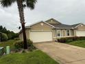 Tan two-car garage home with landscaping and a palm tree at 7633 W Lenox Cir, Punta Gorda, FL 33950