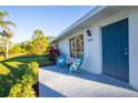 Bright and airy front porch with blue chairs and landscaping at 28041 Pasadena Dr, Punta Gorda, FL 33955