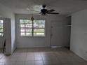 Living room with tiled floors, ceiling fan, and large window at 8274 Herbison Ave, North Port, FL 34287