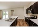 Modern kitchen with dark cabinets, stainless steel appliances, and breakfast bar at 481 Guild St, Port Charlotte, FL 33954