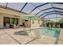 Relaxing pool area with covered patio, lounge chairs, and umbrella at 2636 Mauritania Rd, Punta Gorda, FL 33983