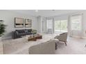 Bright living room with neutral tones, modern furniture, and sliding glass doors to the outdoor space at 25236 Rampart Blvd, Punta Gorda, FL 33983