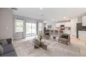 Spacious living area flows into kitchen with white cabinets, island, and outdoor access at 25236 Rampart Blvd, Punta Gorda, FL 33983