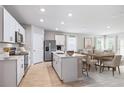 Modern kitchen with white cabinets, island, and stainless steel appliances at 83 Santarem Cir, Punta Gorda, FL 33983