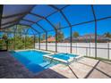 Inviting screened pool and spa area with brick pavers at 14294 Mcfarland Ave, Port Charlotte, FL 33981