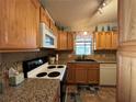 Kitchen with wood cabinets, granite countertops, and modern appliances at 707 Riverview Cir, North Port, FL 34287