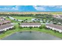 Aerial view of townhomes near a lake with lush green landscaping at 20149 Lagente Cir, Venice, FL 34293