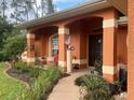 Inviting home exterior featuring a covered porch and well-manicured landscaping at 5163 Jaremko St, North Port, FL 34286