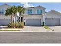 Three-car garage, two-story townhome with gray siding and landscaping at 14640 Sycamore Ct # 2822, Punta Gorda, FL 33955