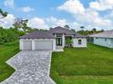 Modern home exterior with gray pavers driveway at 1419 Liggett Cir, Port Charlotte, FL 33953