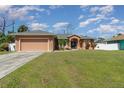 Single-story home with attached garage, driveway, and neat lawn at 1858 Norvell Ave, North Port, FL 34286