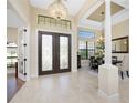 Elegant entryway with double doors, high ceilings, and chandelier at 24211 Savory Ln, Punta Gorda, FL 33955