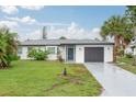 Charming single-story home with a well-maintained lawn, gray garage door, and inviting curb appeal at 25 Caddy Rd, Rotonda West, FL 33947