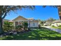 Well maintained villa with lush landscaping and a covered porch at 1307 Red Oak Ln, Port Charlotte, FL 33948