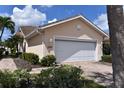 Tan house with white garage door, landscaping, and paved driveway at 3763 Albacete Cir # 77, Punta Gorda, FL 33950