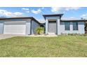 Newly built home with light blue exterior, white garage door, and landscaping at 13164 Amaryllis Cir, Port Charlotte, FL 33981