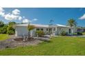 Single story home with metal roof, landscaping, and circular driveway at 22465 Vale Ave, Punta Gorda, FL 33980
