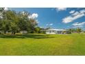 Large backyard with lush grass, mature trees, and shed at 22465 Vale Ave, Punta Gorda, FL 33980