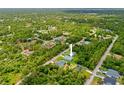 A lush, green aerial shot showcasing a community with the property highlighted via an arrow at 2404 Hanford Ln, North Port, FL 34288