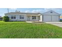 Single story home with two car garage and large lawn at 8109 San Jacinto Ave, North Port, FL 34287
