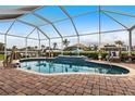 Gorgeous screened-in pool area with brick pavers, water feature, and relaxing seating with waterfront view at 1215 Via Tripoli, Punta Gorda, FL 33950
