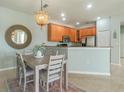 Kitchen and dining area featuring wood cabinets, stainless steel appliances, and a modern chandelier at 2765 Arugula Dr, North Port, FL 34289