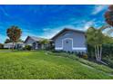 Gray house with white accents and lush landscaping at 1256 Alton Rd, Port Charlotte, FL 33952