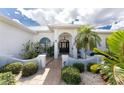 Inviting entryway with a double door, lush landscaping, and a paved walkway at 1945 Jamaica Way, Punta Gorda, FL 33950