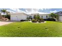 Beautiful waterfront home with a metal roof, two-car garage, and manicured lawn at 1945 Jamaica Way, Punta Gorda, FL 33950