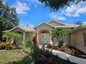 Inviting home showcasing tropical landscaping, a paved walkway, and a beautiful neutral color scheme at 21 Par View Pl, Rotonda West, FL 33947