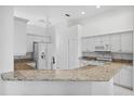 Kitchen boasts granite countertops and white cabinetry at 7116 Quigley St, Englewood, FL 34224