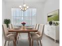 Bright dining room featuring a wood table and six chairs at 7116 Quigley St, Englewood, FL 34224