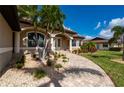 Home exterior showcasing a paved walkway and lush landscaping at 2736 Magdalina Dr, Punta Gorda, FL 33950