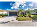 One-story house with a landscaped front yard and a two-car garage at 24080 Buckingham Way, Punta Gorda, FL 33980