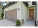 Two-car garage with a brown door and stone accents at 1293 Preston St, Port Charlotte, FL 33952