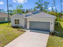 Exterior view of a single-Gathering home with a two-car garage and landscaping at 1301 Preston St, Port Charlotte, FL 33952