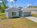 Exterior view of a single-Gathering home with a two-car garage, showing the landscaping at 1301 Preston St, Port Charlotte, FL 33952