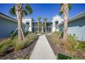 Peaceful courtyard with a walkway, landscaping, and two-story building at 14271 Heritage Landing Blvd # 1526, Punta Gorda, FL 33955