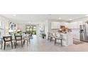 Open-concept living area featuring a dining room, living room and kitchen with wood-look tile flooring at 16402 Bridle Ridge St, Port Charlotte, FL 33953