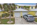 Attached two-car garage with a paved driveway and a parked silver SUV, showcasing convenience and ample parking at 2000 Bal Harbor Blvd # 321, Punta Gorda, FL 33950