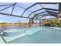 A pristine pool with a spa overlooking a scenic pond, all enclosed within a screened lanai at 24004 Vincent Ave, Punta Gorda, FL 33955